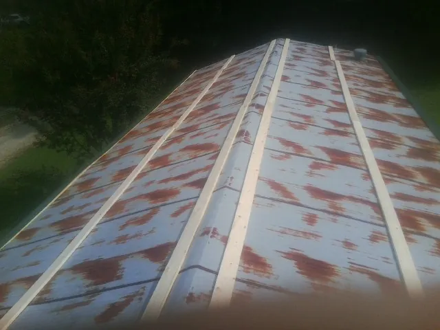 Rusted metal roof panels with new wood purlins before replacement — Storm Damage Roof Repair in Clearville by Roofing Brothers