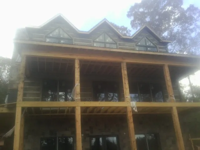 Dormers and porch framing on a large log home under construction in Clearville